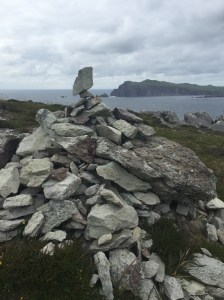 One of many stone cairns with cliffs and the ocean visible in the background