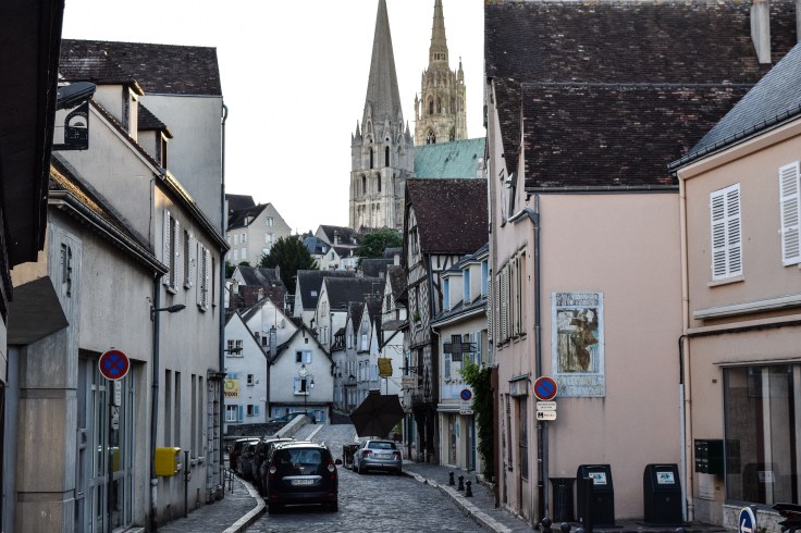 A street in Chartres showing a mixture of architecture and the cathedral at the top of the hill