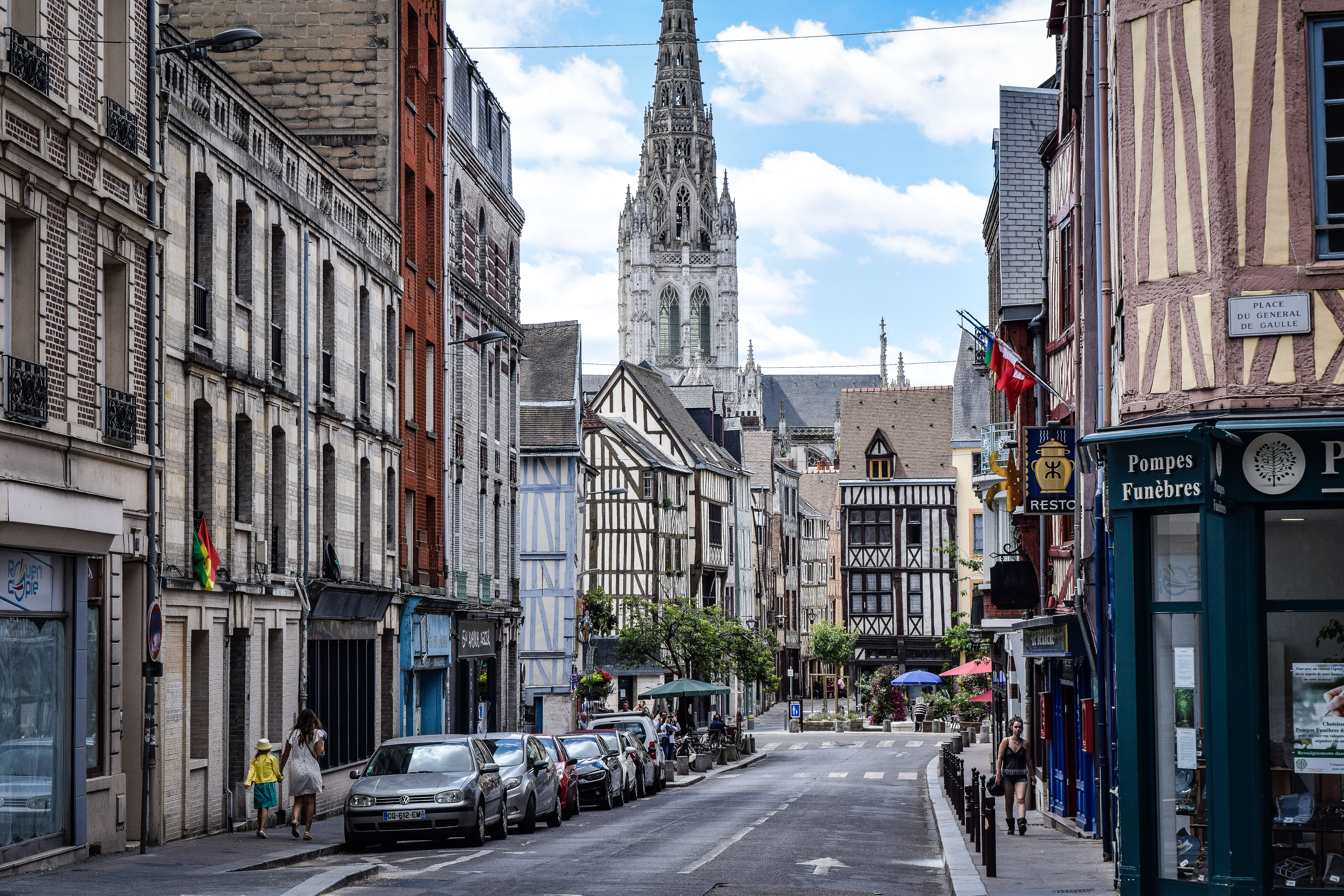 A street in Rouen full of half-timbered houses and the spire of a cathedral