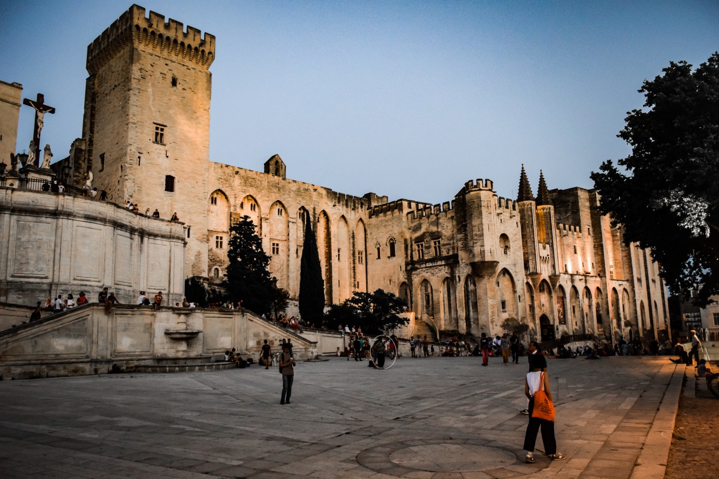 The Palace of the Popes and surrounding plaza filled with street performers in Avignon