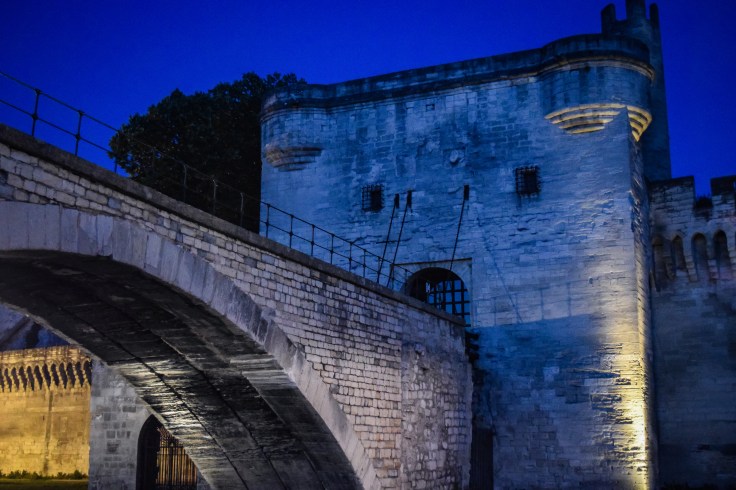 A gatehouse stands at the end of the Pont d'Avignon at dusk