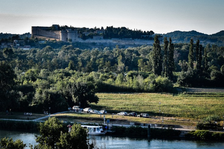 The walls and gatehouse of Fort Saint-Andre from a distance surrounded by trees