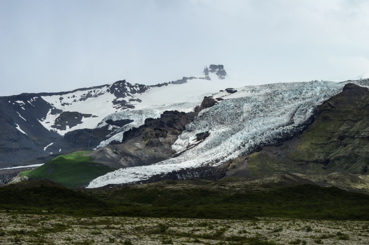 A glacier creeps slowly down the mountainside in Iceland