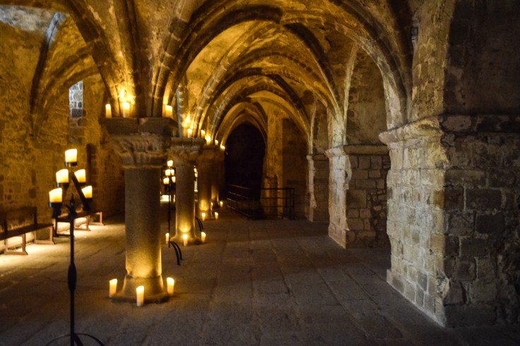 A candlelit vaulted gallery inside Mont Saint Michel